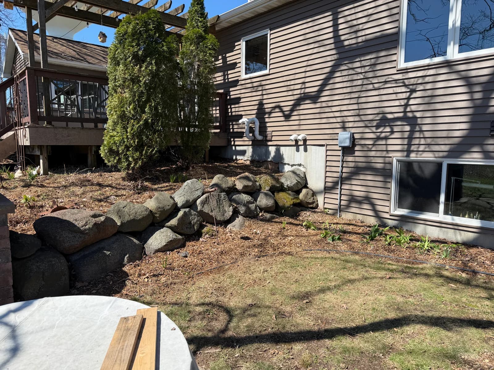 Clean garden area with rock retaining wall after spring cleanup